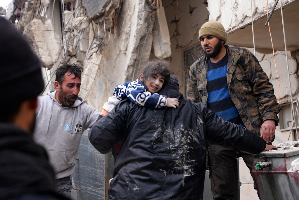 Residents retrieve a small child from the rubble of a collapsed building following an earthquake in the town of Jandaris, in the countryside of Syria's northwestern city of Afrin in the rebel-held part of Aleppo province, on February 6, 2023. Hundreds have been reportedly killed in north Syria after a 7.8-magnitude earthquake that originated in Turkey and was felt across neighbouring countries.
Rami al SAYED / AFP
